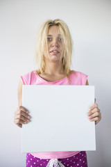 Naklejka premium Portrait of woman suffering from cold holding blank placard against gray background