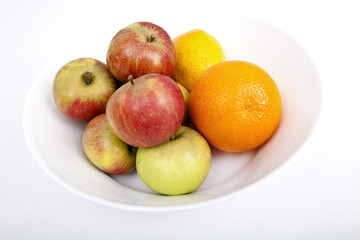 Naklejka na ściany i meble Fresh fruits in plate against white background