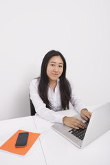 Portrait of confident businesswoman working on laptop in office