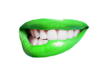 Close-up of teeth biting green lip over white background