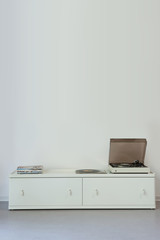 Fototapeta premium Record player on cabinet against wall