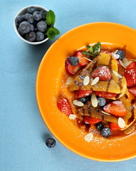 Two pancakes hearts with strawberry, blueberries  and almond