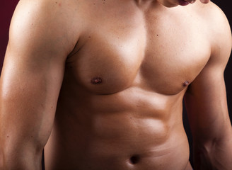 Fototapeta na wymiar Cropped image of a beautiful man torso against black background