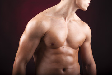 Cropped image of a beautiful man torso against black background