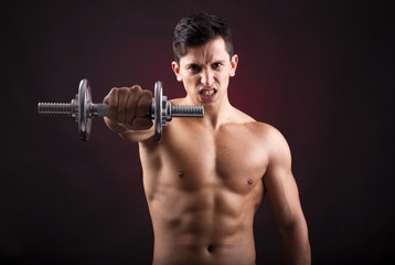 Image of a muscular young man lifting weights on black backgroun