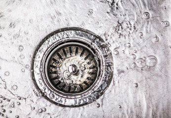 Water flowing down the hole in a kitchen sink