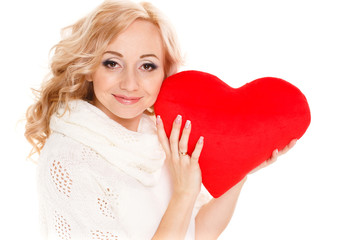 Pregnant woman holding a red heart pillow in hand on white