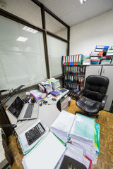 Office room with leather armchair and table with documents