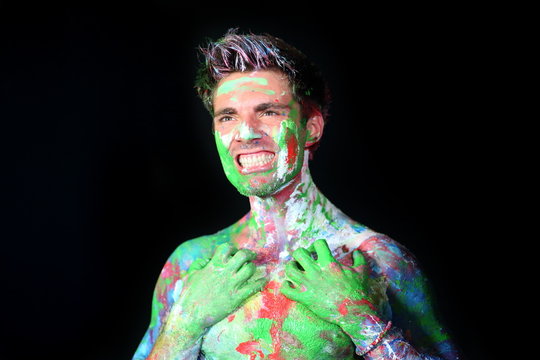 Man bares his teeth all in paint in the studio