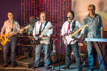 The musical group of five men on stage in a club