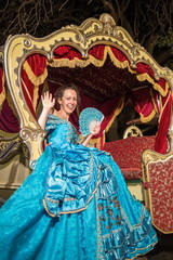 Fototapeta premium girl in blue old-fashioned dress sits in a carriage