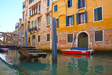 Fototapeta na wymiar Narrow canal with boats in Venice, Italy