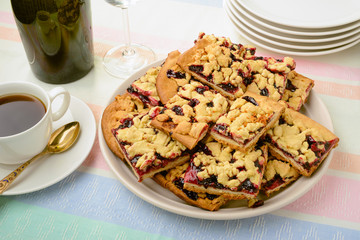 Pieces of blackberry jam grated pie with coffee and champagne