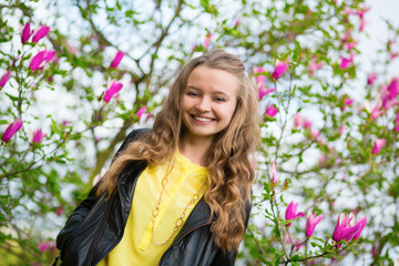 Girl with blooming magnolia in the background