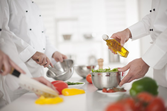 anonymous hands preparing food in professional kitchen