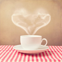 Coffee cup with heart shape steam over grunge background