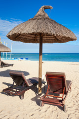 parasol de paille et transats sur plage de Maurice
