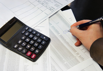 Office table with calculator, pen and accounting document