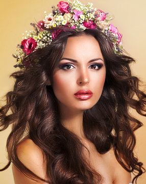 Young Beauty with Wreath of Flowers. Perfect Brown Hairs. Luxury