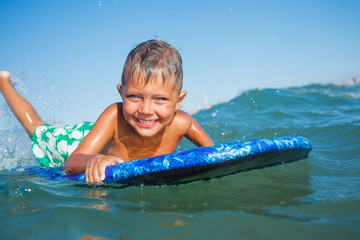 Fototapeta na wymiar boy has fun with the surfboard