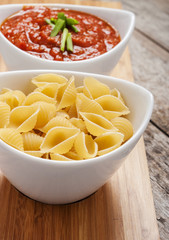tomato sauce and pasta on wooden background