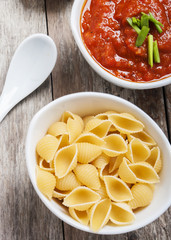 tomato sauce and pasta on wooden background