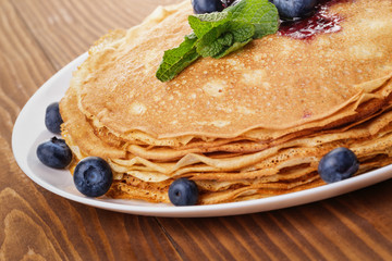 homemade blinis or crepes with blueberries and jam