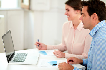 Fototapeta premium Male and female cowokers looking at laptop