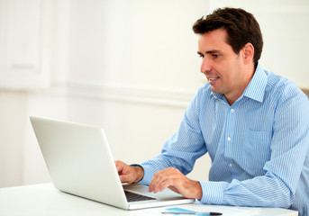 Fototapeta premium Attractive adult businessman using his laptop