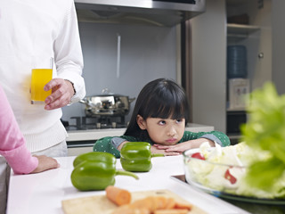 little girl appears to be unhappy in kitchen
