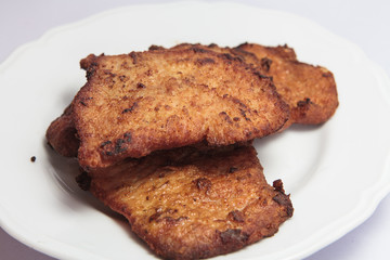 Four hot pork cutlets on white background