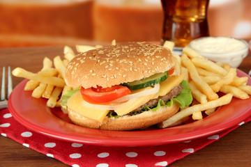 Tasty cheeseburger with fried potatoes and cold drink,