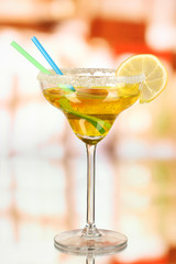 Yellow cocktail in glass on room background