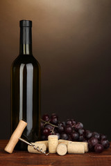 Wine and corks on wooden table on brown background