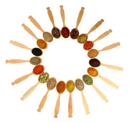 Assortment of spices in wooden spoons, isolated on white
