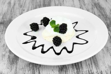Tasty meringue cake with berries on wooden table