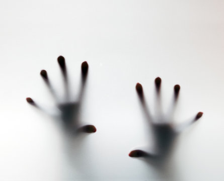 Hands touching frosted glass. Conceptual scream for help