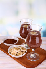 Cocktails with banana and chocolate on table on light