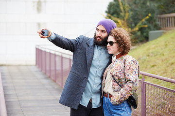 Couple taking a photograph of themselves with a smartphone
