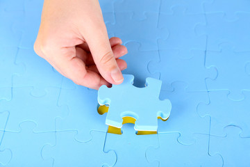 Hand holding puzzle piece, close up