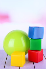 Bright ball and colorful  cubes on table on bright background