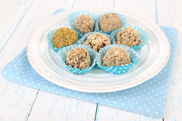 Set of chocolate candies, on plate, on wooden background