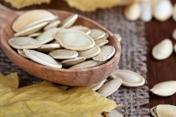 Pumpkin seeds in spoon on sackcloth background