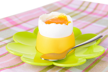 Boiled egg in egg cup on table close-up