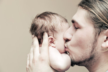 Father with his young baby cuddling and kissing him on cheek