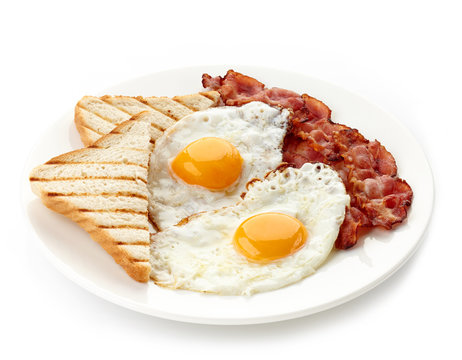 Breakfast with fried eggs, bacon and toasts