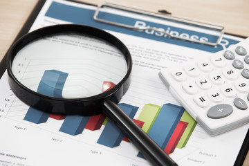magnifying glass and pen over graph