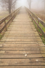 Obraz premium Detail of wooden bridge bath with fog.