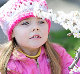 beautiful little girl near a flowering tree