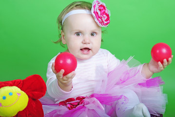 Fototapeta na wymiar Small girl in rose suit on green background